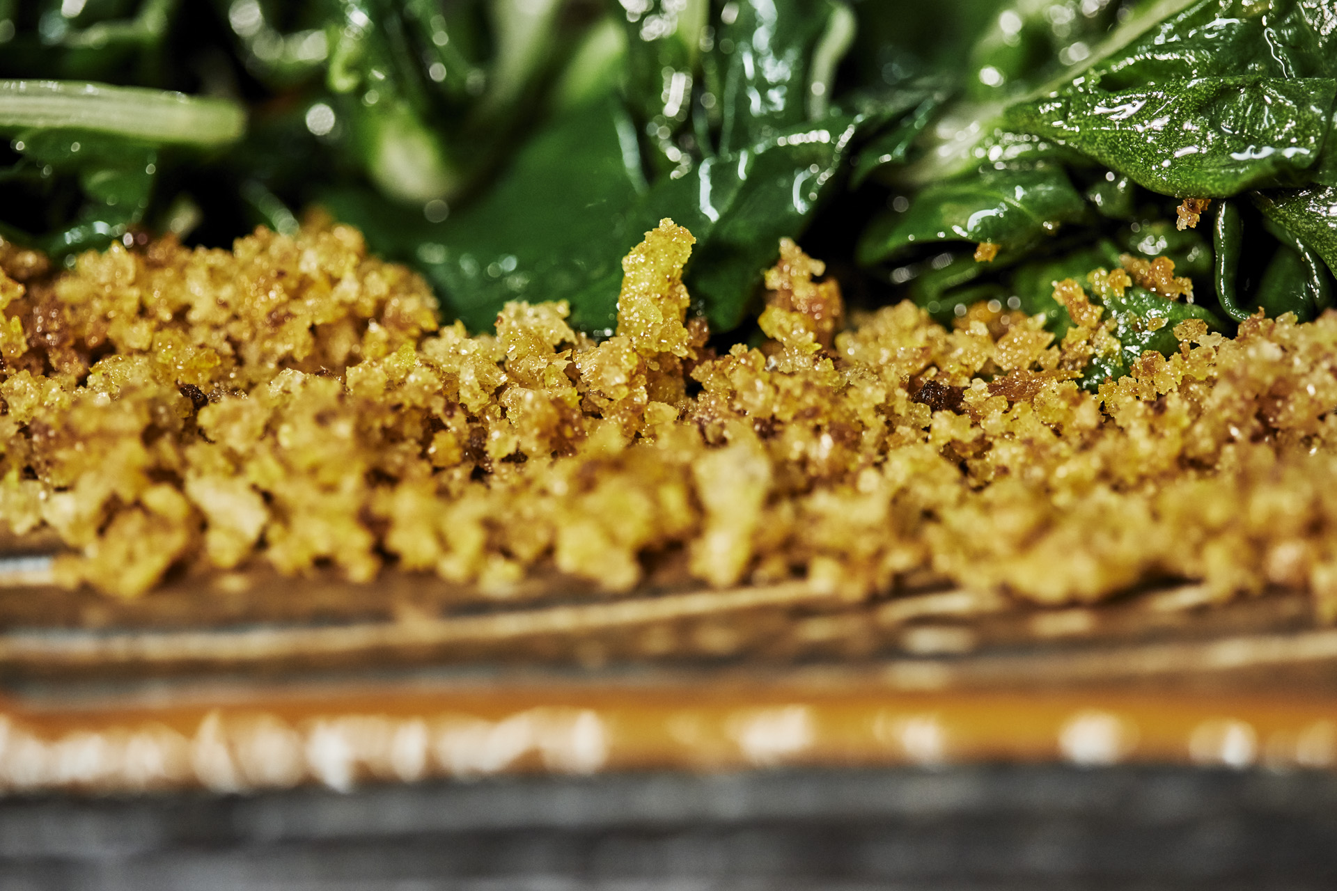 Close-up of crispy breadcrumbs soaked in extra virgin olive oil, highlighting texture and richness.